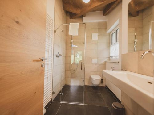 a bathroom with a toilet and a sink and a shower at Chalet Anna XL Leogang in Leogang