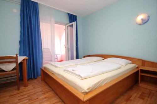 łóżko w pokoju z niebieskimi ścianami i oknem w obiekcie Triple Room Peroj 2235a w mieście Peroj
