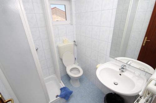 biała łazienka z toaletą i umywalką w obiekcie Triple Room Peroj 2235a w mieście Peroj