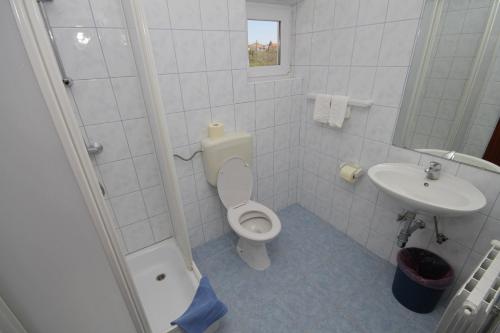een witte badkamer met een toilet en een wastafel bij Triple Room Peroj 2235f in Peroj