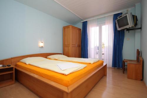 a bedroom with a large bed and a tv at Double Room Peroj 2235h in Peroj