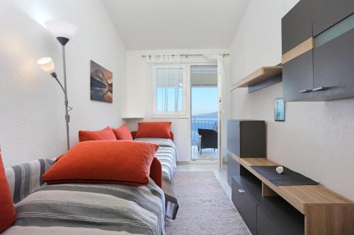Duas camas com almofadas laranja num quarto em Apartments by the sea Okrug Donji, Ciovo - 19974 em Okrug Gornji
