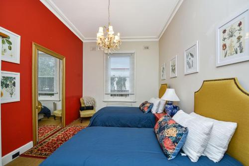 a bedroom with a blue bed and red walls at Coolangatta in Katoomba