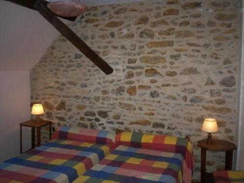 - une chambre avec un canapé et un mur en pierre dans l'établissement Gîte Joué-l'Abbé, 4 pièces, 5 personnes - FR-1-410-128, à Joué-lʼAbbé