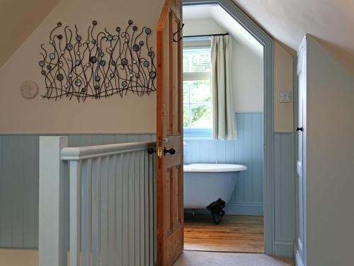 ロイヤル・タンブリッジ・ウェルズにあるSawmill Cottageのバスルーム(バスタブ付)、窓が備わります。