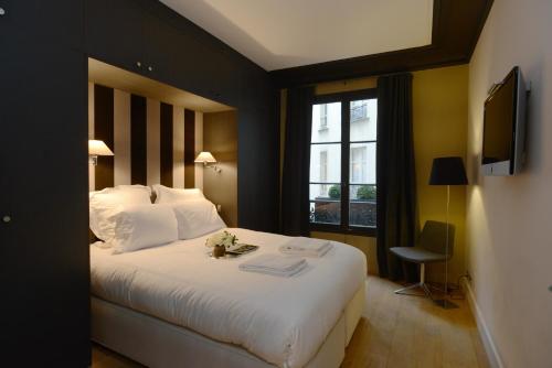 a bedroom with a large white bed and a window at Appartement Paris Tour Eiffel in Paris