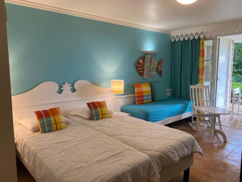 a bedroom with a large bed and a blue wall at Studio RDC La Désirade Martinique accès direct plage in Sainte-Luce