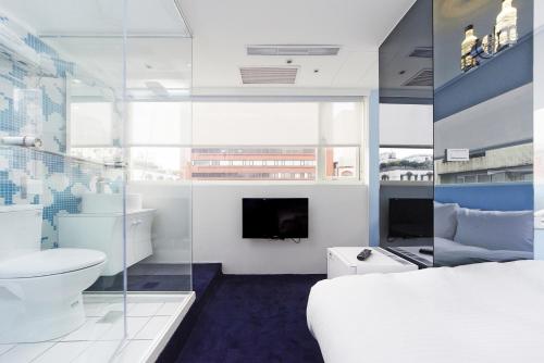 a bedroom with a bed and a toilet and a tv at Forever Inn in Taipei