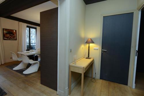 Zimmer mit einem Schreibtisch und einem Tisch mit einer Lampe in der Unterkunft Appartement Paris Tour Eiffel in Paris
