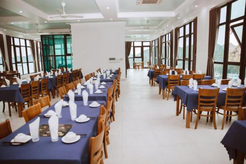 una sala banchetti con tavoli e sedie blu di Thuỷ Anh Hotel a Cat Ba