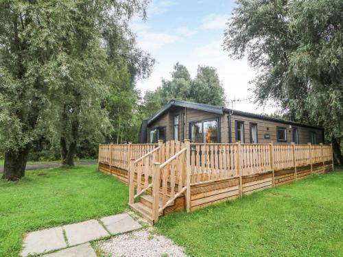 a house with a wooden fence in a yard at Coniston View 9 in Carnforth