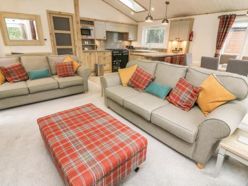 a living room with two couches and a kitchen at Coniston View 9 in Carnforth
