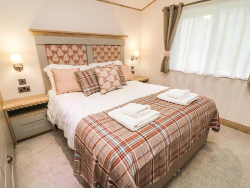 um quarto com uma cama com duas toalhas em Coniston View 9 em Carnforth