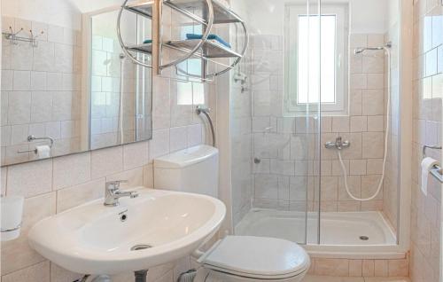 een badkamer met een wastafel, een toilet en een douche bij Amazing Apartment In Vinisce With Kitchen in Vinišće