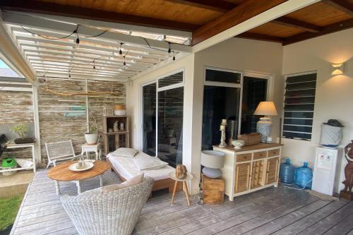 a patio with a couch and a table on a deck at Villa WABISABI cosy home in Punaauia