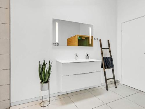a white bathroom with a sink and a mirror at Modern Retreat in Graerup - By Traum Ferienwohnungen in Oksbøl