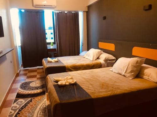 um quarto de hotel com duas camas e uma janela em Royal Hotel em Qinā
