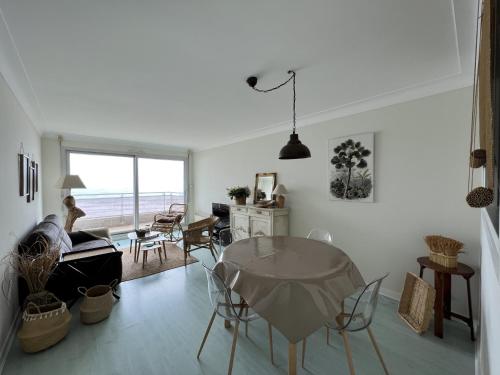 un salon avec une table en verre et des chaises dans l'établissement Appartement familial face mer avec balcon - FR-1-485-95, à Les Sables-dʼOlonne
