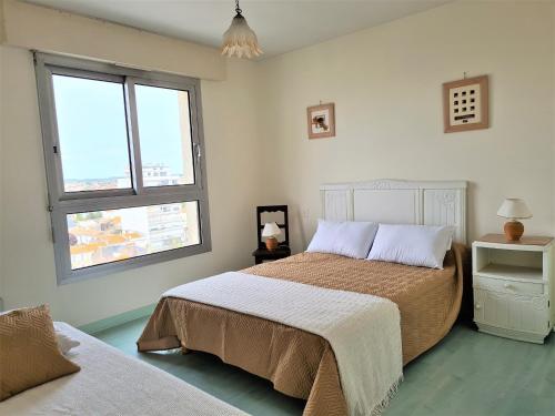 une chambre avec deux lits et deux fenêtres dans l'établissement Appartement familial face mer avec balcon - FR-1-485-95, à Les Sables-dʼOlonne