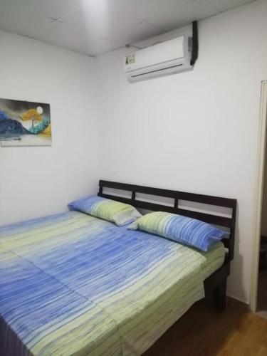Un dormitorio con una cama con almohadas azules. en Hostal My House Your House, en David