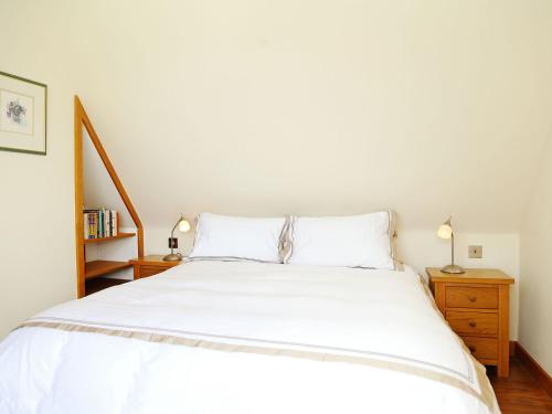 レナムにあるHonywood Cottageのベッドルーム1室(白いベッド1台、ナイトスタンド2台付)