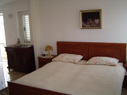 sypialnia z łóżkiem i zdjęciem na ścianie w obiekcie Apartments Ivory w Dubrowniku