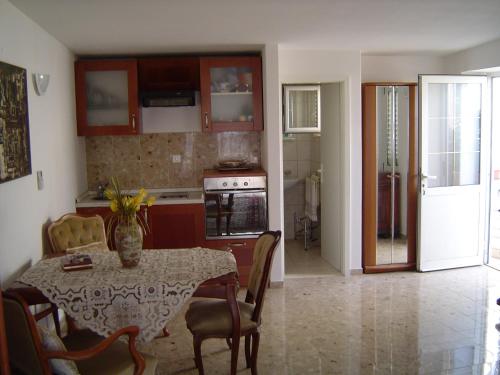 eine Küche mit einem Tisch und Stühlen sowie eine Küche mit einem Tisch und einem Tisch in der Unterkunft Apartments Ivory in Dubrovnik