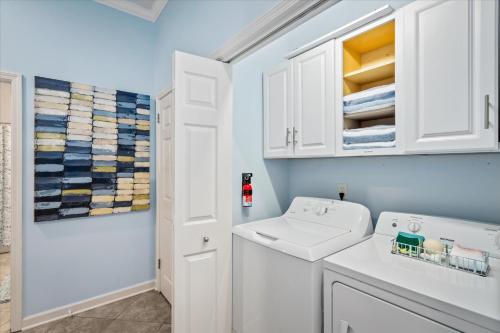 a white bathroom with a sink and a washing machine at The Pelican Place - Amazing Views, Top Floor Condo in Dauphin Island