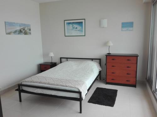 une chambre avec un lit et une commode en bois dans l'établissement Appartement T3, vue plage, 2 ch, centre Les Sables-d'Olonne - FR-1-331-51, à Les Sables-dʼOlonne