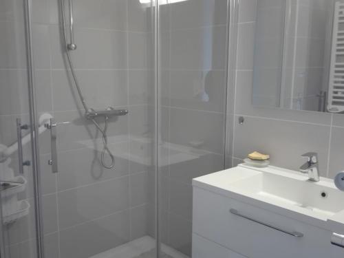 une salle de bain blanche avec une douche et un lavabo dans l'établissement Appartement T3, vue plage, 2 ch, centre Les Sables-d'Olonne - FR-1-331-51, à Les Sables-dʼOlonne
