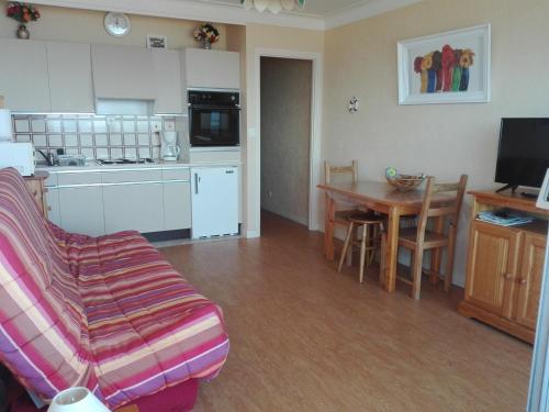 un salon avec un canapé et une cuisine avec une table dans l'établissement Studio face à la mer avec balcon, proche centre - FR-1-331-55, à Les Sables-dʼOlonne