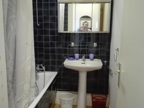 une personne prenant une photo d'une salle de bains avec lavabo dans l'établissement Studio face à la mer avec balcon, proche centre - FR-1-331-55, à Les Sables-dʼOlonne