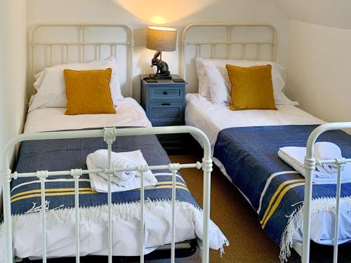 two beds sitting next to each other in a bedroom at Moorhen Cottage in Hollingbourne