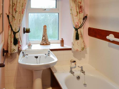 baño con lavabo y ventana en Regina Cottage, en Bradpole