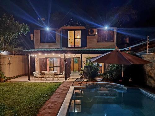 una casa con piscina por la noche en La Morada del Sol en Puerto Iguazú
