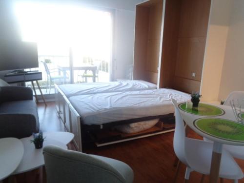 une chambre avec un lit, une table et des chaises dans l'établissement Studio 24m² au Centre d'Arcachon, proche Gare et Plage, Balcon Sud - FR-1-374-104, à Arcachon
