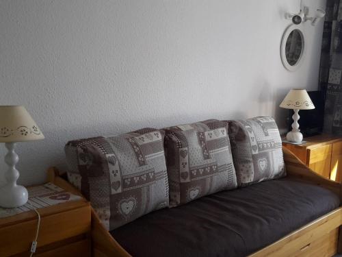 - un canapé avec des oreillers dans l'établissement Appartement Skis aux Pieds, 4 Personnes, Balcon, Wifi Gratuit, Proche Commerces et Activités - FR-1-574-39, aux Menuires