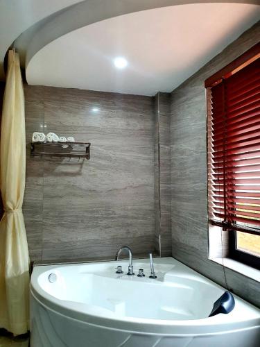 a white bath tub in a bathroom with a window at Khách sạn Đại Dương Diễn Châu - Nghệ An in Diễn Châu