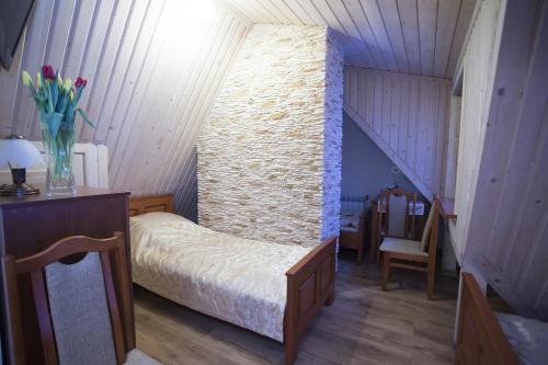 a bedroom with a bed and a stone wall at U Gruloka in Poronin