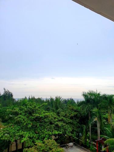 a view from the balcony of a resort with palm trees at Khách sạn Đại Dương Diễn Châu - Nghệ An in Diễn Châu