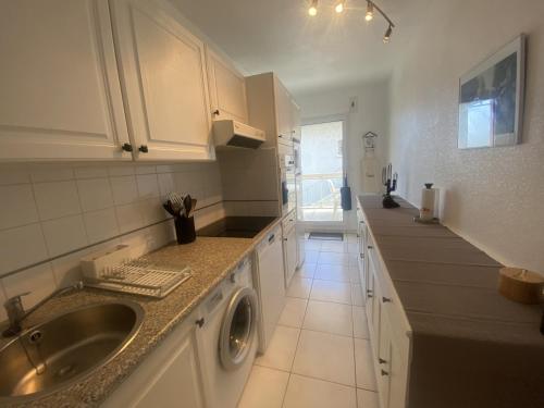 une cuisine avec un évier et une machine à laver dans l'établissement T3 à Arcachon avec vue mer, parking privé et Wi-Fi - FR-1-374-180, à Arcachon