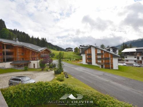 une route dans un village avec des maisons et une voiture dans l'établissement Spacieux T4 proche des pistes avec terrasse et parking - 6-8 pers. - FR-1-685-22, aux Gets