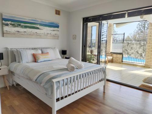 1 dormitorio con cama blanca y ventana grande en Citadel Suite, en Port Macquarie