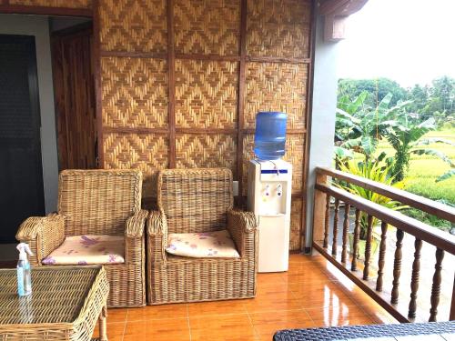 two wicker chairs and a water heater on a porch at MIOKI HOMETEL in Batuan