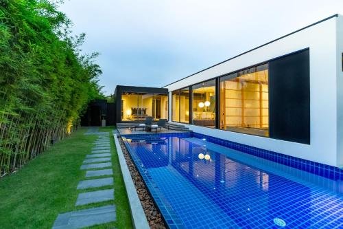 a swimming pool in the backyard of a house at Villoft Zen Living Resort in Thalang