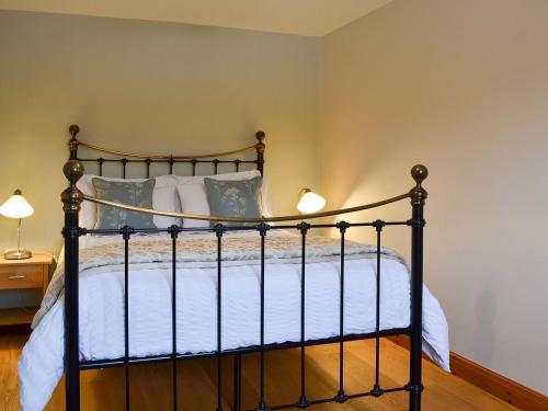 a bedroom with a black bed with white sheets and pillows at The Wests in Lastingham