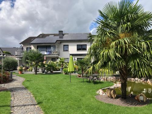 a house with a palm tree in front of a yard at Ferienwohnung am Pferdemarkt in Konz