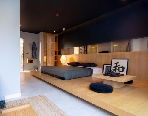 um quarto com uma cama grande e um banco de madeira em Villoft Zen Living Resort em Thalang