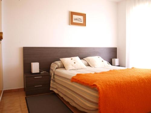 1 dormitorio con 1 cama con manta naranja en ApartUP La Concha Beachfront I, en Oropesa del Mar