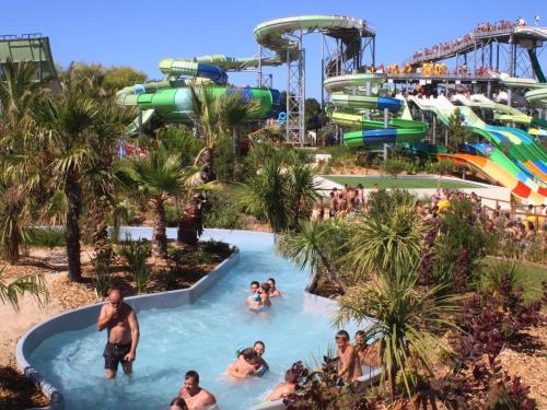 - un groupe de personnes dans une piscine d'un parc aquatique dans l'établissement Appartement avec balcon-terrasse, parking privatif et accès plage à Longeville-sur-Mer - FR-1-336-28, à Longeville-sur-Mer